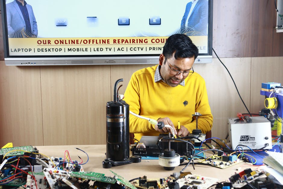 Technician repairing an air conditioner unit in New Delhi workshop.
